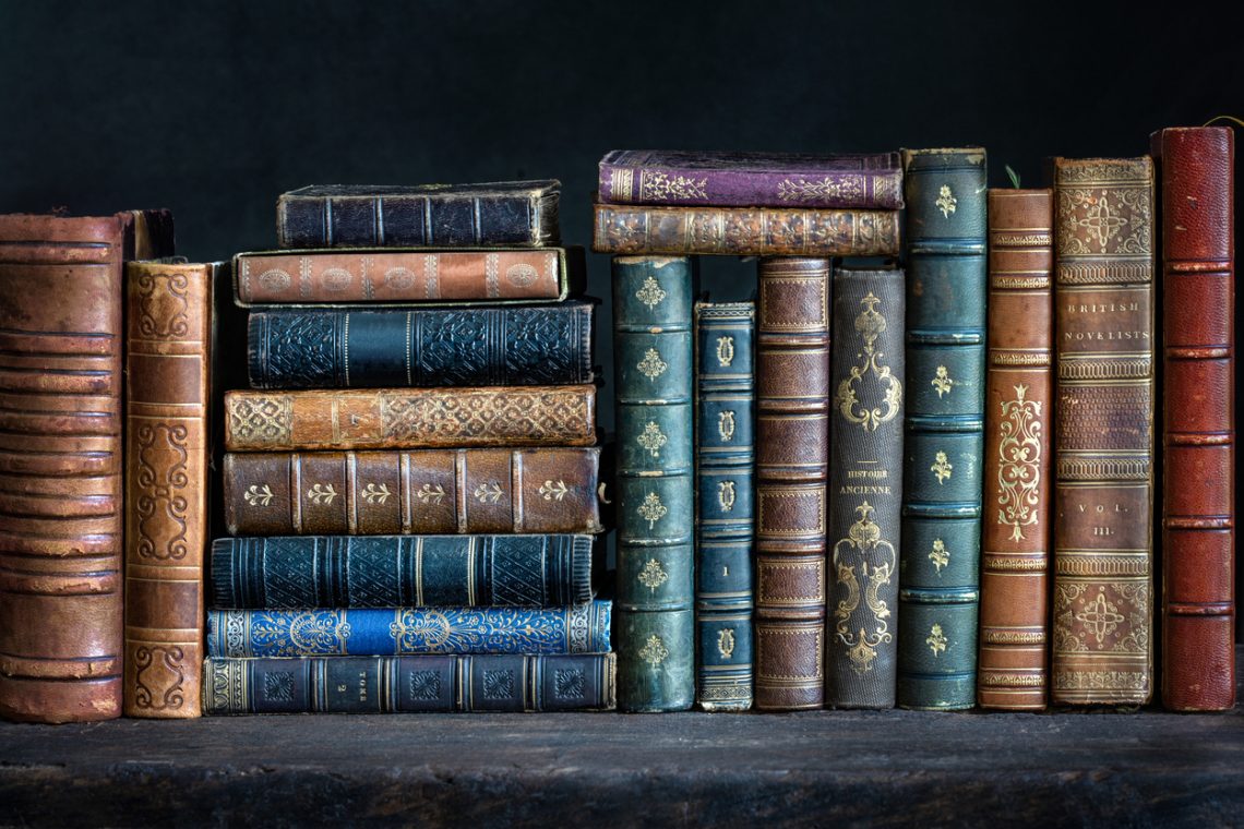 Old books on wooden shelf. Tiled Bookshelf background.  Concept on the theme of history, nostalgia, old age. Retro style.